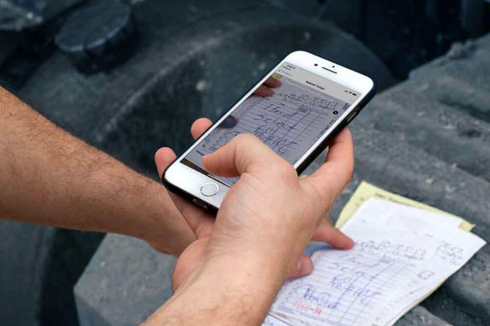 hand using a mobile phone to scale a paper ticket